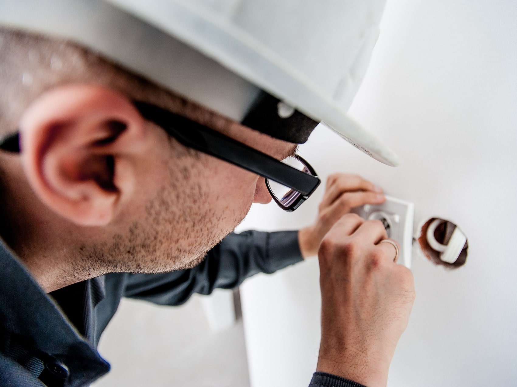 Photo of an electrician inspecting an electrical device