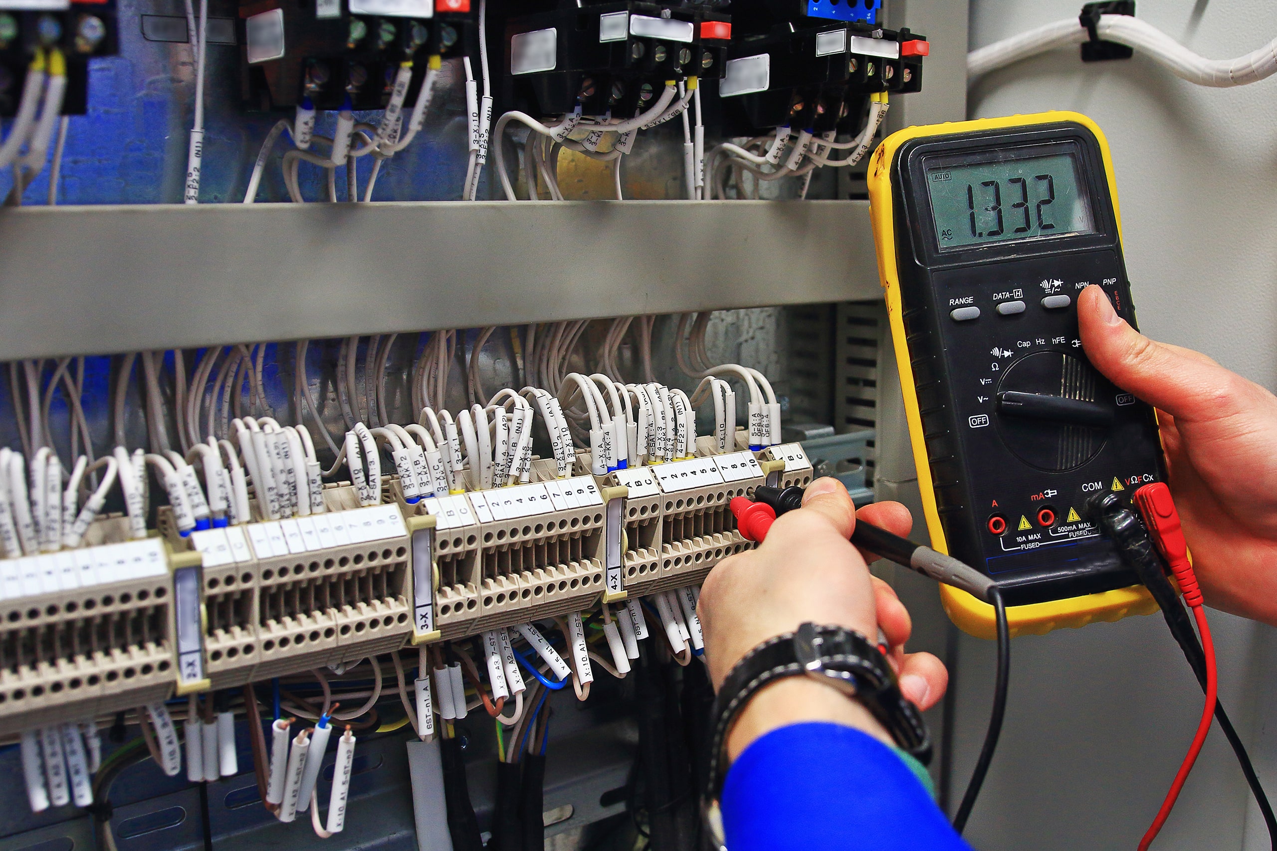 Photo of an electrician testing electrical components with a voltmeter