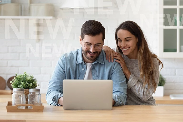 Photo of 2 people looking at a laptop